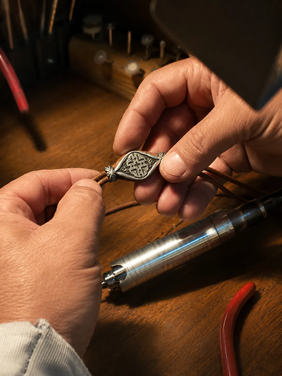 Central silver ornament being assembled onto the bracelet