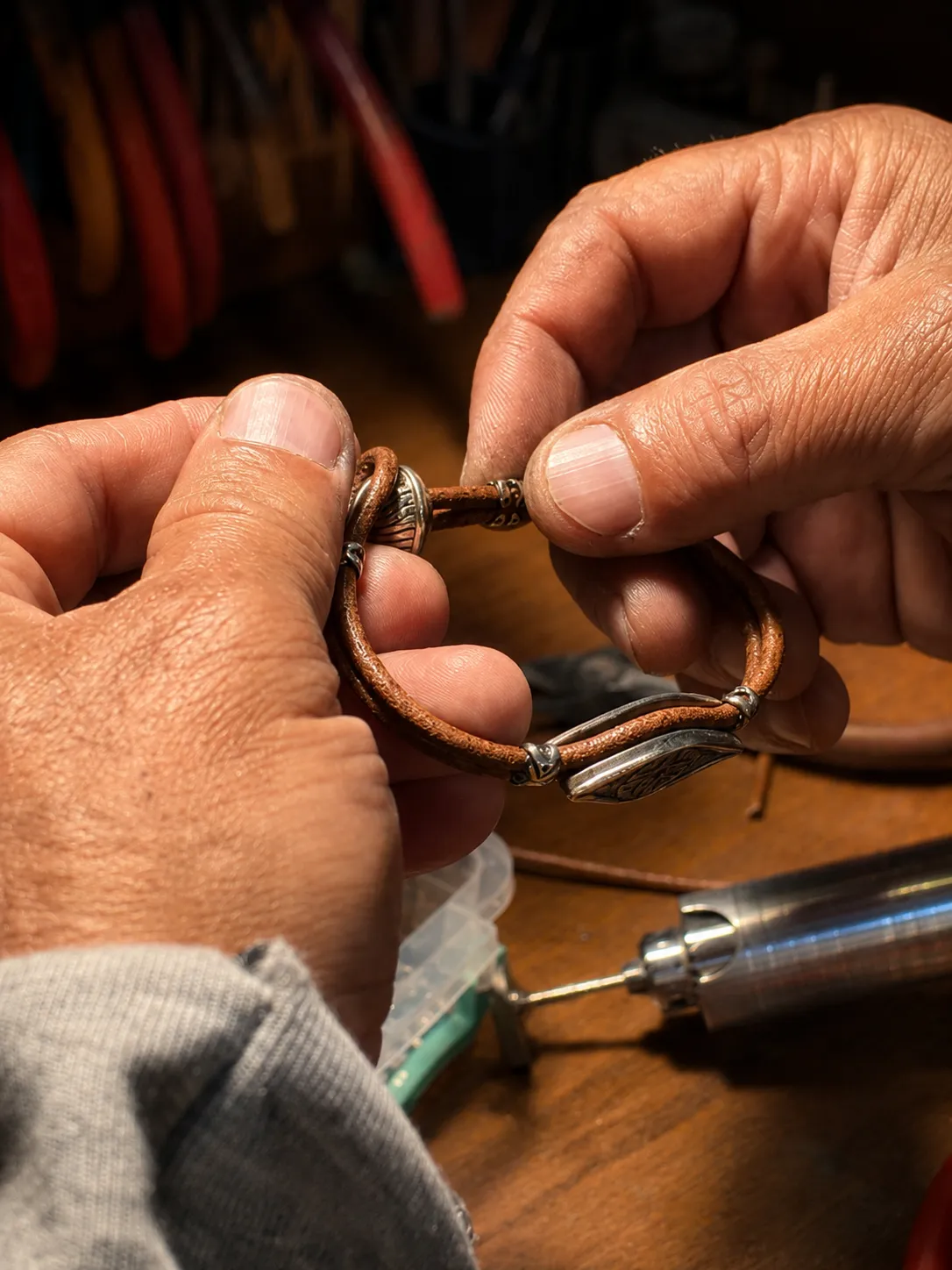Artisan inspecting the finished handcrafted bu-neba silver bracelet in his hands